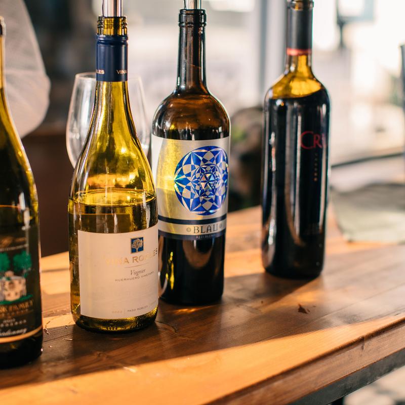 Several bottles of wine lined up on a counter.