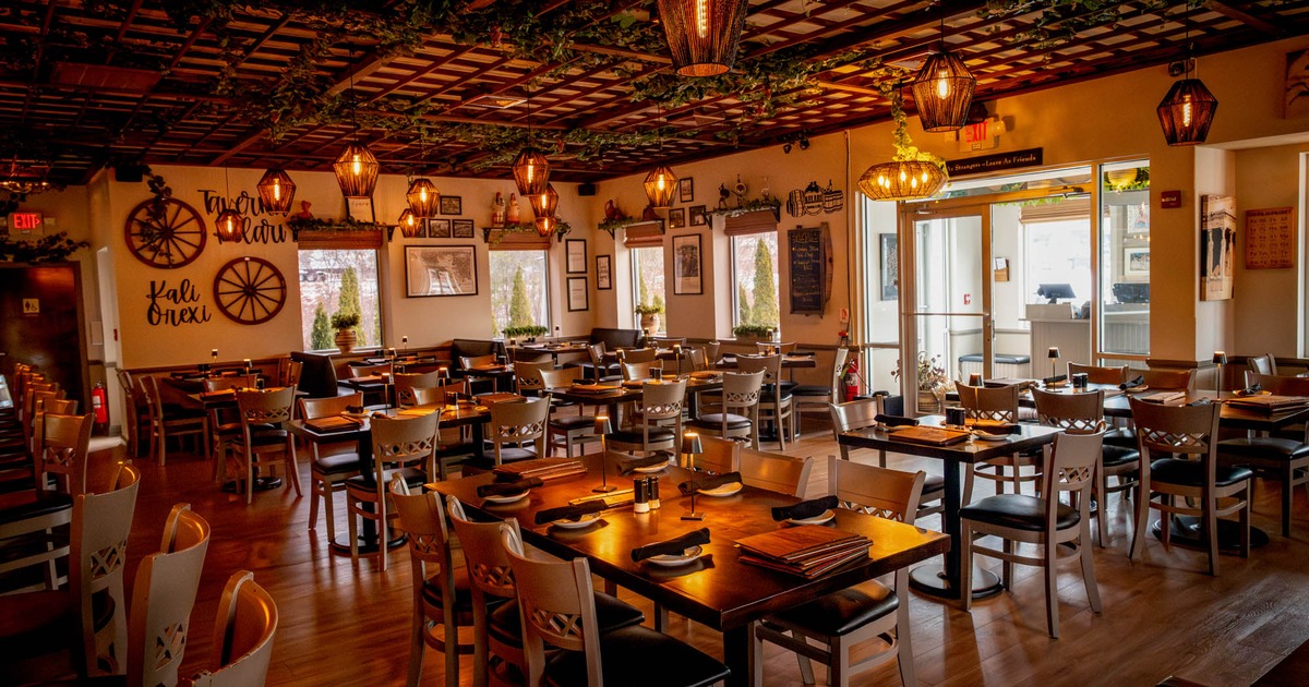 Interior, dining area, tables for six, four and two, bar on the left, entrance on the right