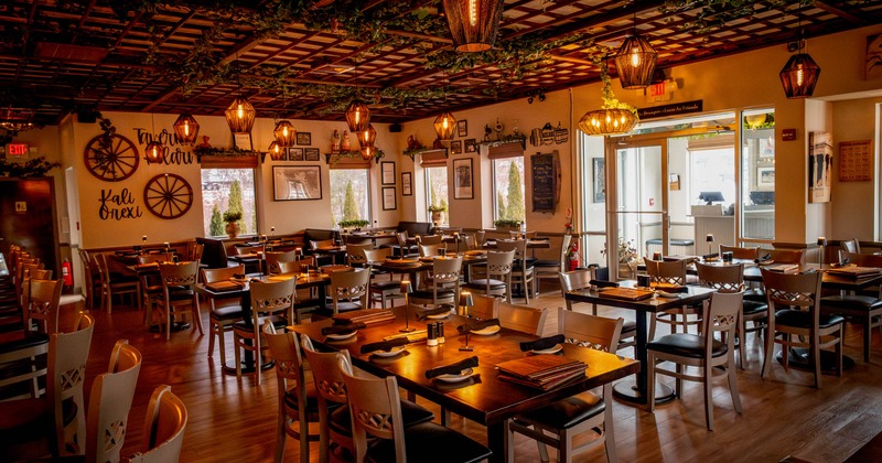 Interior, dining area, tables for six, four and two, bar on the left, entrance on the right