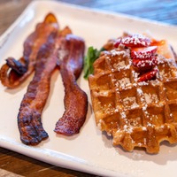 Belgian waffles topped with whipped butter and syrup, served with applewood smoked bacon or fruit.