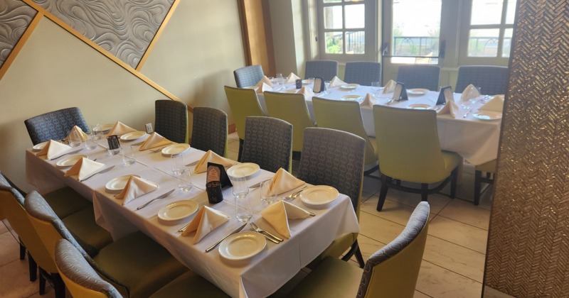 Interior of cozy and stylish dining area with dining tables set for guests