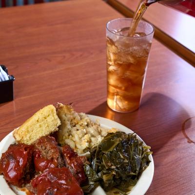 Meat loaf with collard greens, mac and cheese, cornbread, and an Iced Tea.