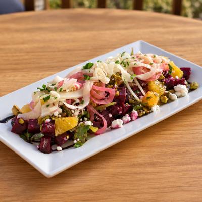 Roasted Beet Salad with goat cheese, onions, arugula, citrus, and pistachios.