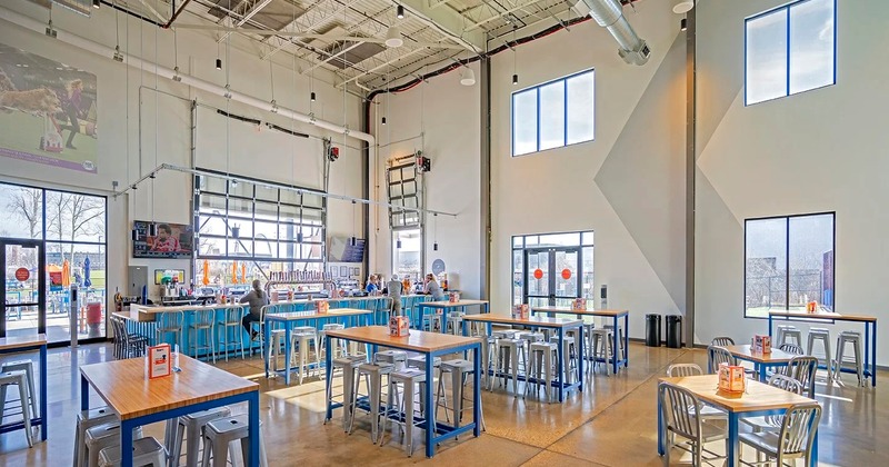 Indoor seating area with high-top tables, stools and a counter
