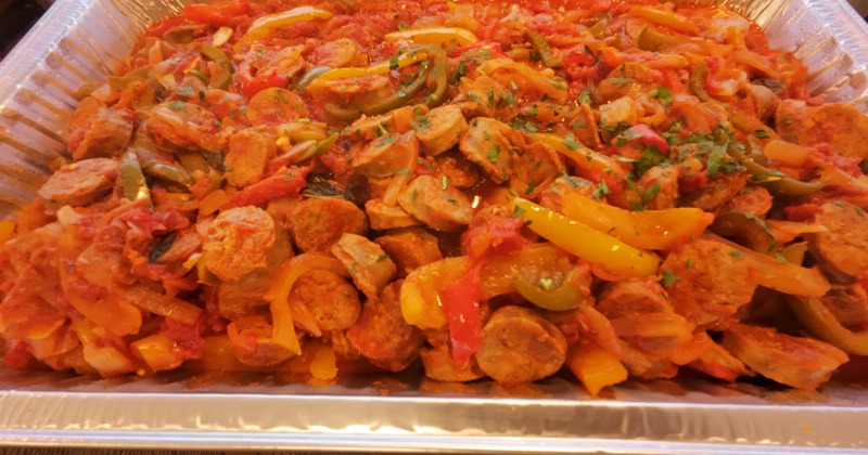 Sausage and peppers with sauce in a catering tray