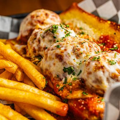 Meatball sandwich with fries.