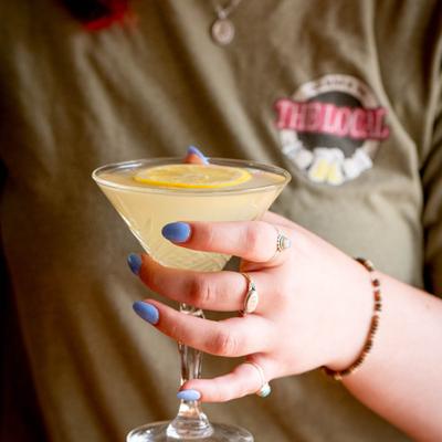 A person holding a lemon drop martini.