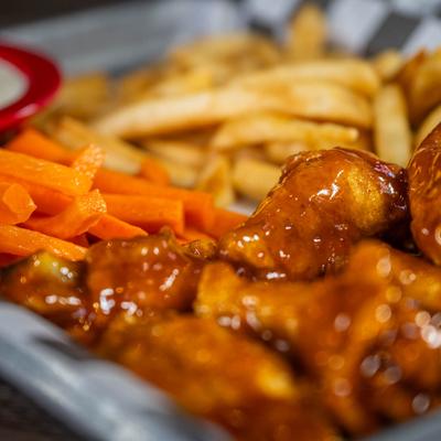 Wings with fries and carrot sticks, close-up.