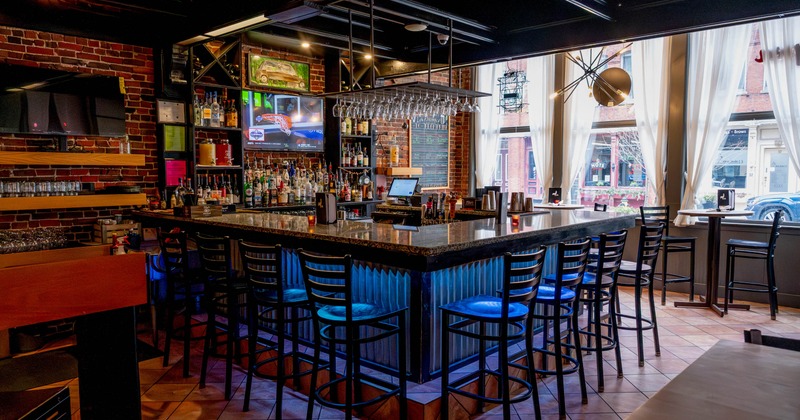 Interior, bar area, marble top bar with stools, checkout counter, drink shelves in the back