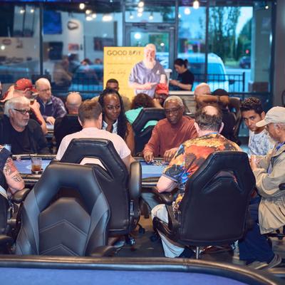 A group of people playing poker in a busy gaming area.