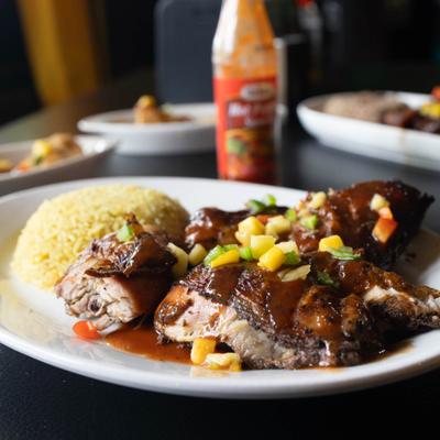 Jerk chicken served with rice on the side.