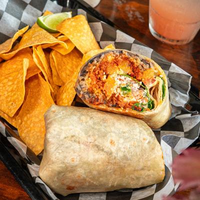 Jamaican-style jerk chicken burrito with tortilla chips.