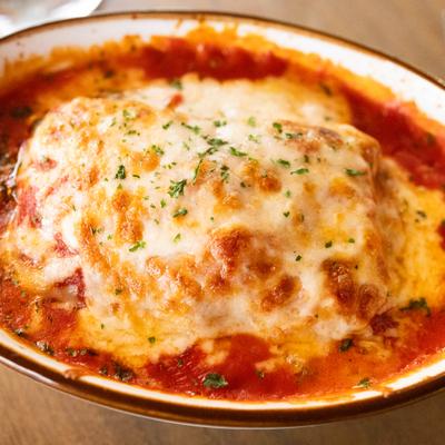 Lasagna topped with melted cheese and herbs, close-up.