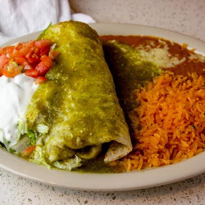 Burrito smothered in green sauce,, served with salad, sour cream, rice, and refried beans.