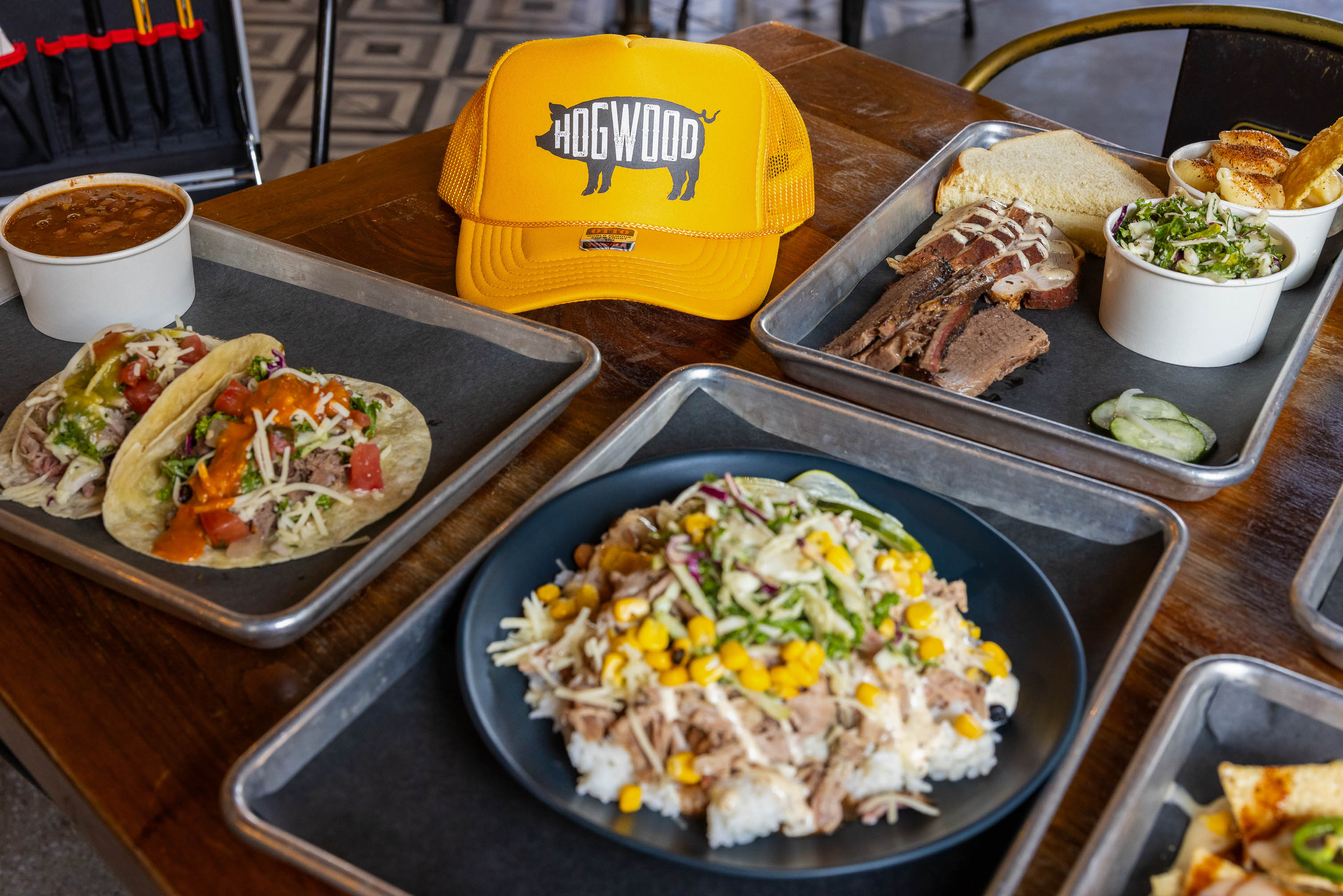 Pork Smoked Bowl, served with other dishes and hat with restaurant's sign