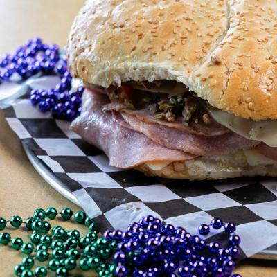 Muffuletta sandwich with meats and melted cheese, close-up.