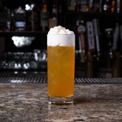 The Hyde and Seek cocktail served in a tall glass with foamy top.