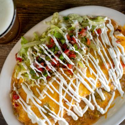 Smothered Burrito topped with melted cheeses and sour cream, served with a salad.