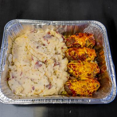 Mini meatloaf served with a side of mashed potato.