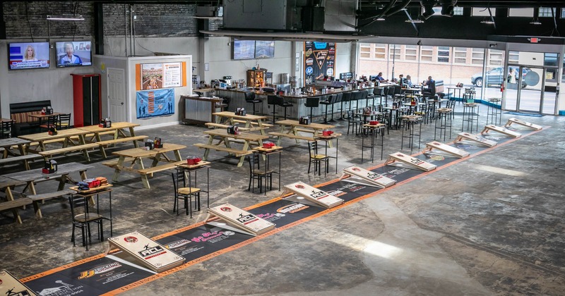 Interior, seating area, bar area in the back, TVs on the wall