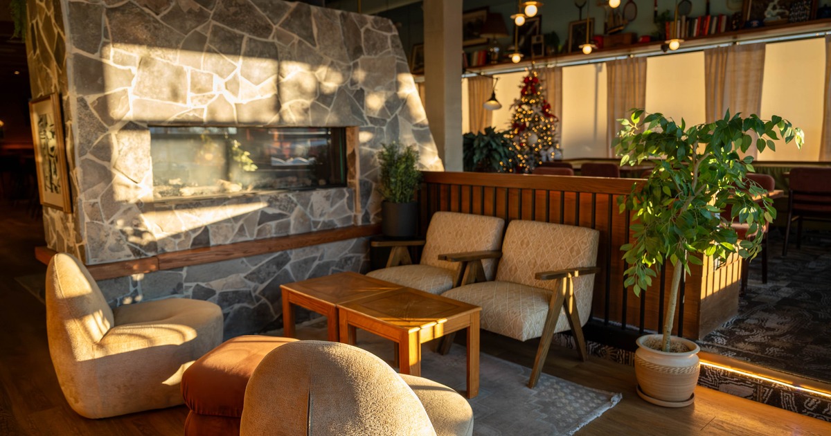 Interior with large stone fireplace, chairs and a wooden coffee table