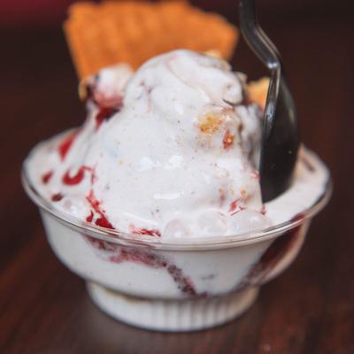 Strawberry vanilla ice cream sundae served with a spoon.