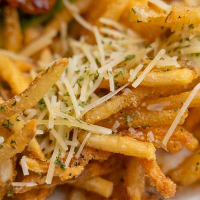Fries topped with grated cheese, close-up.