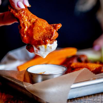 Chicken wing dipped in ranch sauce.