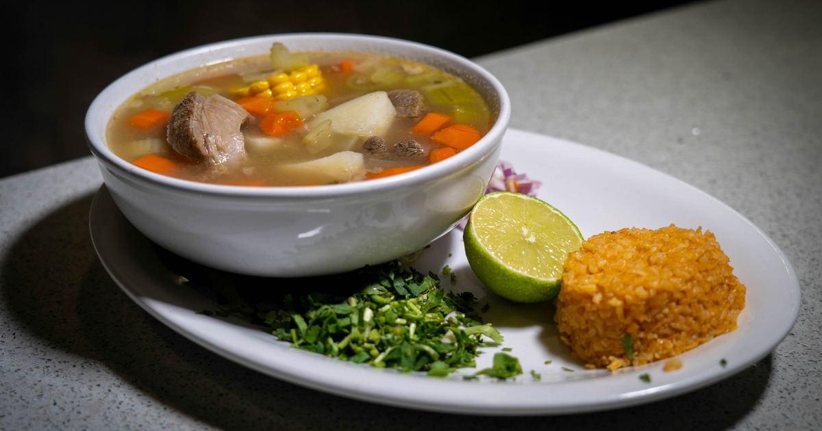 Caldo de Res soup served with rice, lime, chopped onion and cilantro