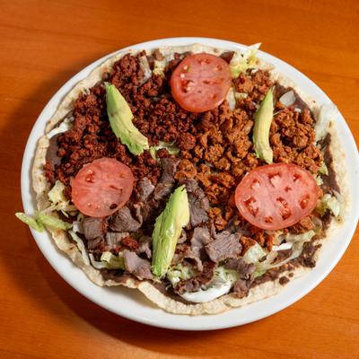 Mexican pizza topped with beef, chorizo, tomatoes and avocado.