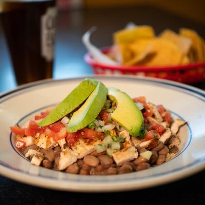 Grilled chicken bowl, with beans, rice, tomatoes, onions, cilantro, and avocado.