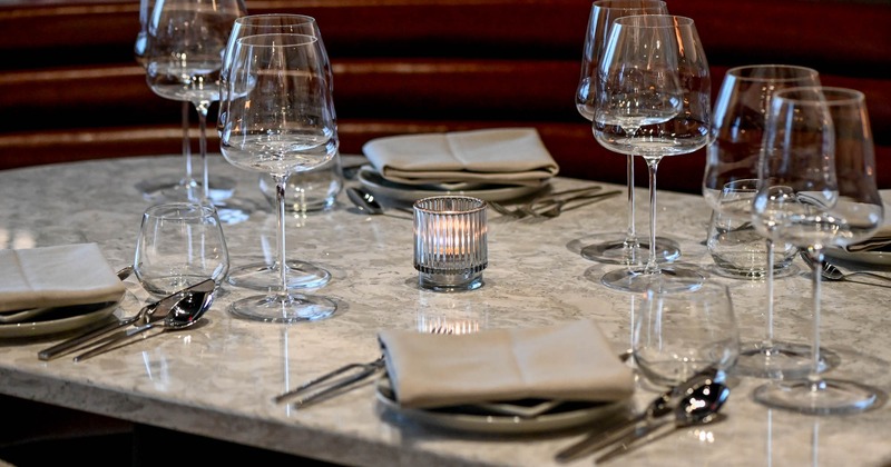 Dining table with plates, glasses, napkins, and utensils