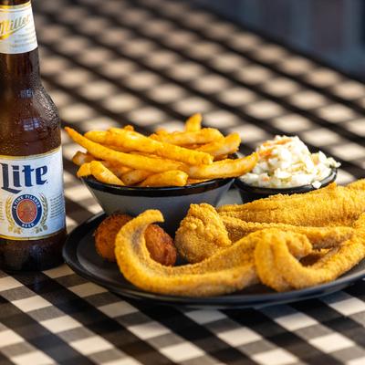 Fish and chips, served with coleslaw, hushpuppies, and a beer lon the side.