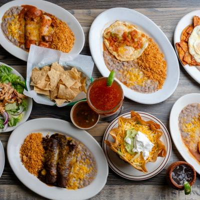 Various dishes served on the table with drinks and condiments.