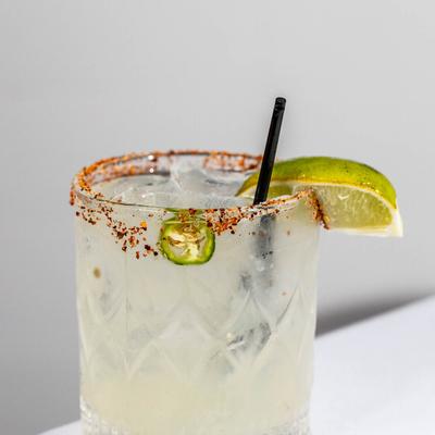 Spicy Margarita glass garnished with chili powder on the rim,  lime and jalapeno slice.