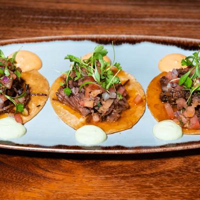 Short Rib Mini Tacos, with chipotle aioli, cream, pickled red onion, and cilantro.