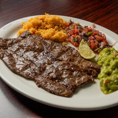 Carne Asada served with rice, pico de gallo, guacamole and a lime wedge.