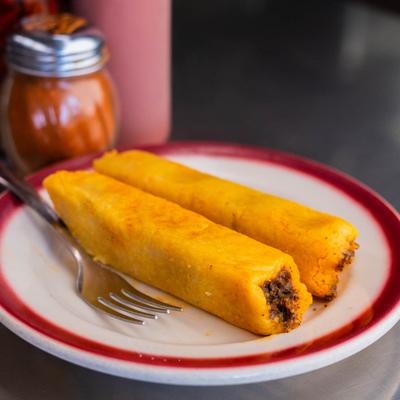 Two tamales on a plate, close-up.