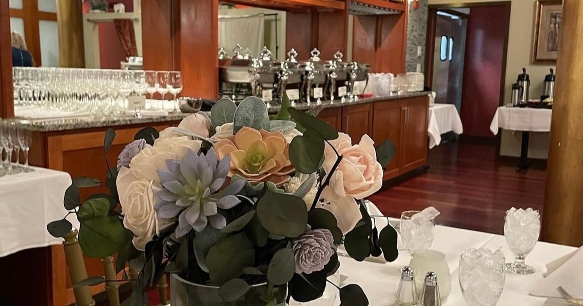 Flower centerpiece arrangement alongside table set for an event