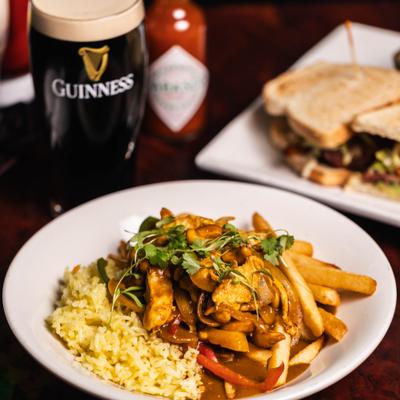 Traditional Irish chicken curry with rice and fries served with a pint of Guinness.