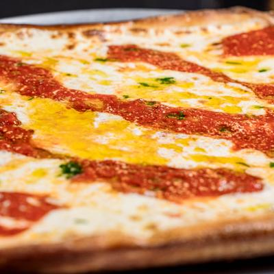 Square pizza with cheese and marinara sauce.