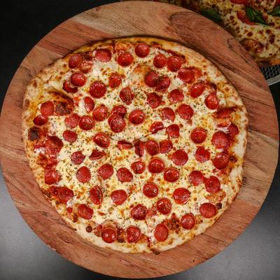 Pepperoni pizza on a wooden tray, overhead view.