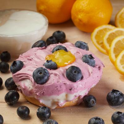 Donut topped with blueberry cream cheese, fresh blueberries, and lemon curd.