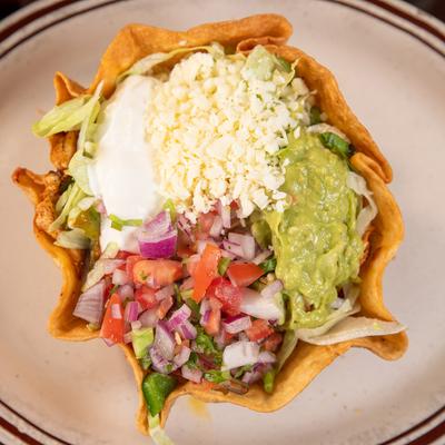 Taco salad, with bell peppers, onions, tomatoes, lettuce, sour cream, guac, pico, and cheese.