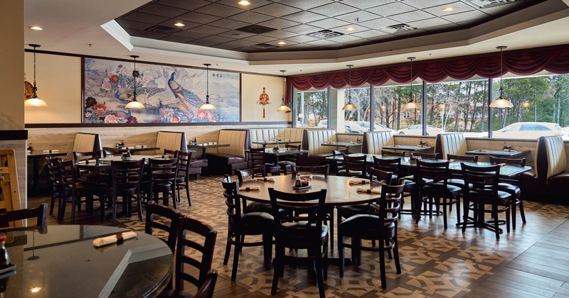 Interior, open space dining area, wooden tables with chairs, seating booths with tables