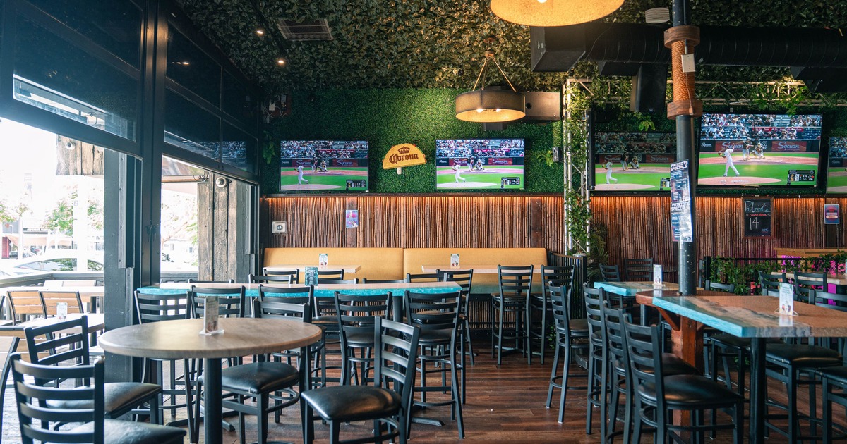 Sports bar interior with high-top tables and multiple TVs