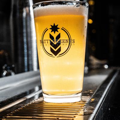 Cold draft beer in a branded pint glass.