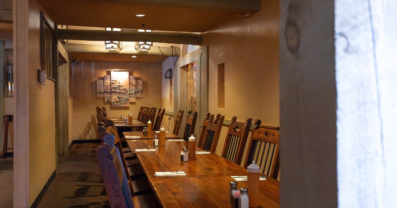 Interior, dining area, long table setup for fourteen and ten people, carpet flooring