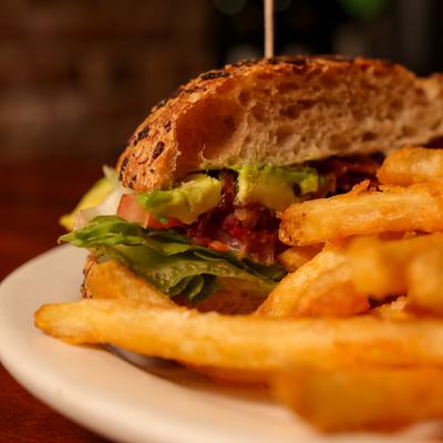 BLT and avocado sandwich, with fries.