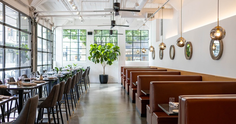 Interior, high tables and chairs on the left and booths on the right